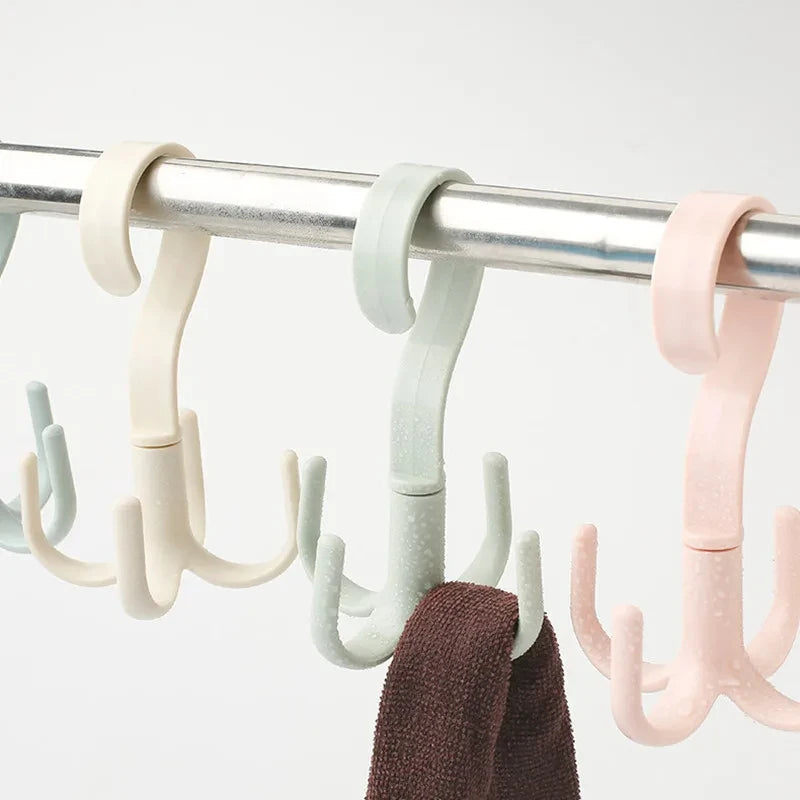 A close-up of a light colored multi-functional hanging hook with four claws hanging from a metal bar.