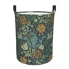 A vintage floral laundry hamper with a dark green and gold pattern, featuring large leaves and flowers.
