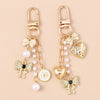 Gold-toned pearl bow heart keychain with dangling charms for bags and keys