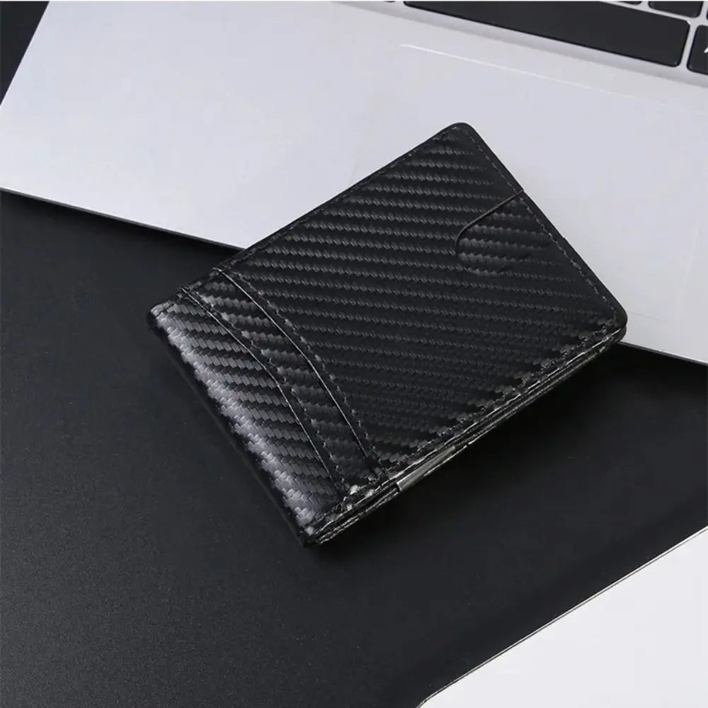 Black carbon fiber texture slim RFID-blocking credit card holder wallet placed on a dark surface.