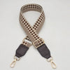 A beige and brown checkered braided nylon bag strap with metal hooks.