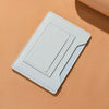 Portefeuille de voyage fin bleu clair pour passeport et documents, posé sur une surface beige.