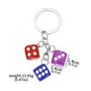 A silver keychain charm featuring three colored dice: red, purple, and blue.