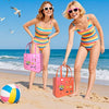 Deux femmes sur une plage tenant un sac de plage rose et un ballon coloré avec l'océan en arrière-plan