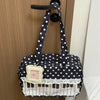A navy blue tote bag with white polka dots featuring a piano lace trim and bow.