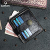 A black genuine leather card wallet with a stitched design and multiple card slots is displayed on a dark gray fabric with sc