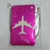 A pink durable aluminum luggage tag with a white airplane silhouette inside clear plastic packaging.