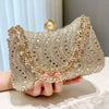 A close-up of a gold and diamond rhinestone clutch bag being held by a hand.