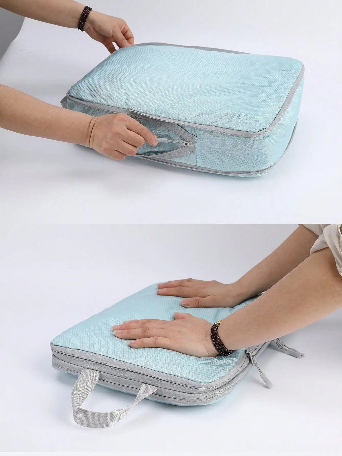 A hand is opening a light blue fabric travel organizer bag, showing its vertical design and storage features.