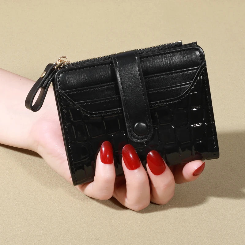 A hand holds a black PU leather card wallet with a double zip closure.