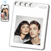 A white photo transfer tag featuring a portrait of a young woman and a young man.
