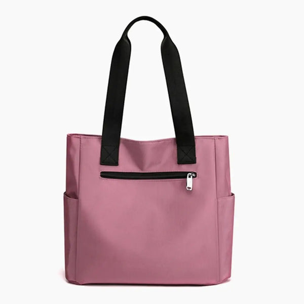 A pink nylon shoulder tote bag with black straps and a zippered pocket.