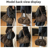 Model back view display of a leopard print canvas tote bag with an adjustable shoulder strap.