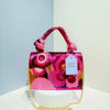A pink and magenta sequin embroidered floral clutch bag with a gold chain strap displayed on a white surface.