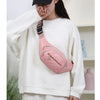 A person wearing a white sweatshirt is holding a pink quilted nylon crossbody belt bag.