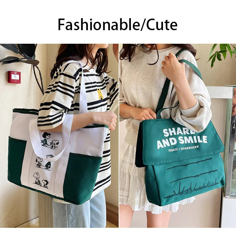 A woman is holding a green Snoopy canvas tote bag in a light-colored outfit.