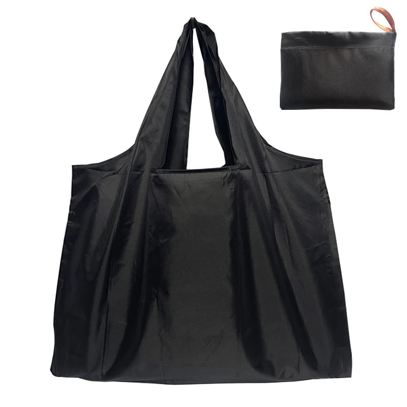 Black foldable water-resistant shopping tote bag with shoulder straps shown in a flat lay view.