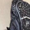 A black backpack featuring a butterfly print design and mesh panel.