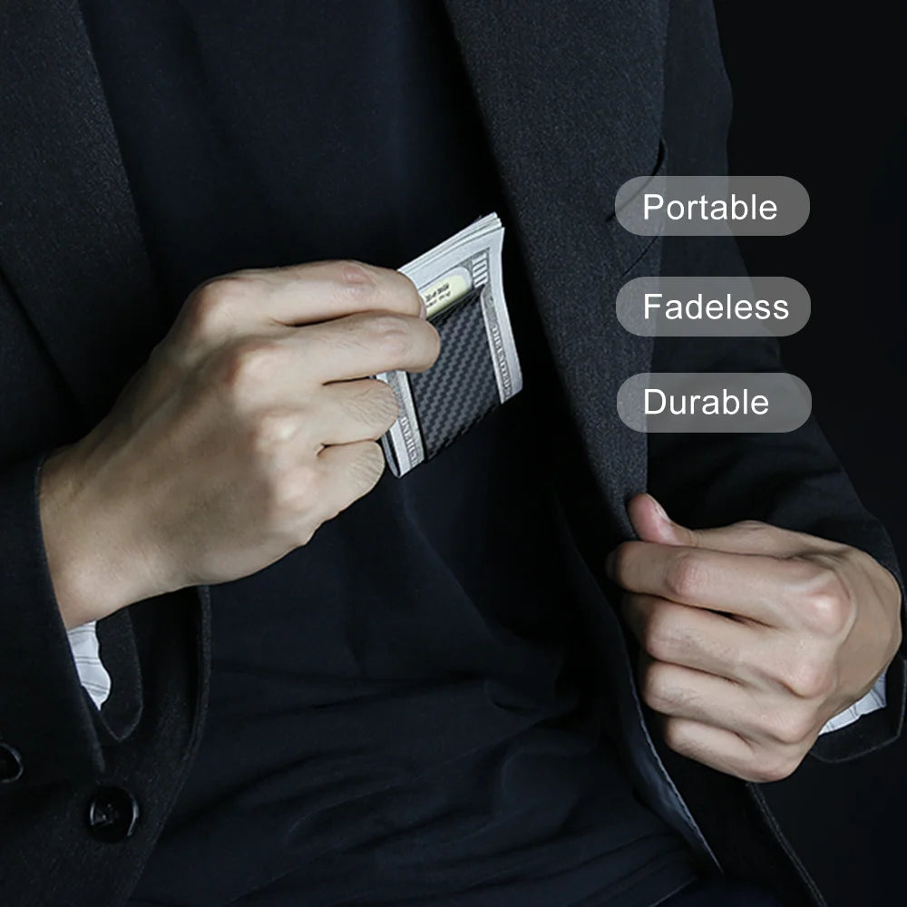 A hand holds a black carbon fiber money clip against a dark suit jacket, highlighting its portable, fadeless, and durable fea