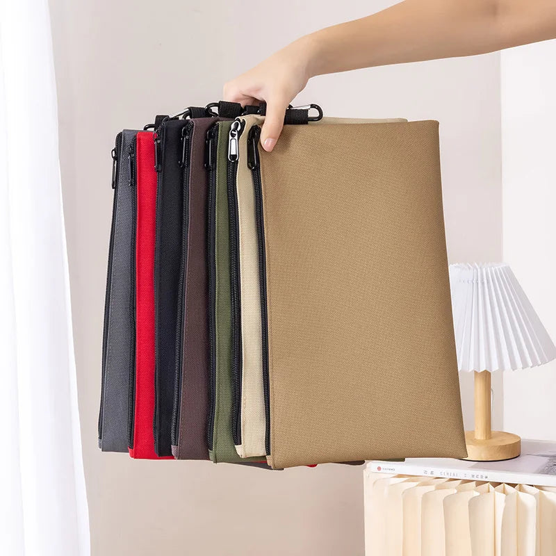 A hand is holding a multi-functional organizer tool kit bag with multiple colored vertical compartments.