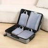 A gray travel compression packing cube set with a black case is open on a light surface.