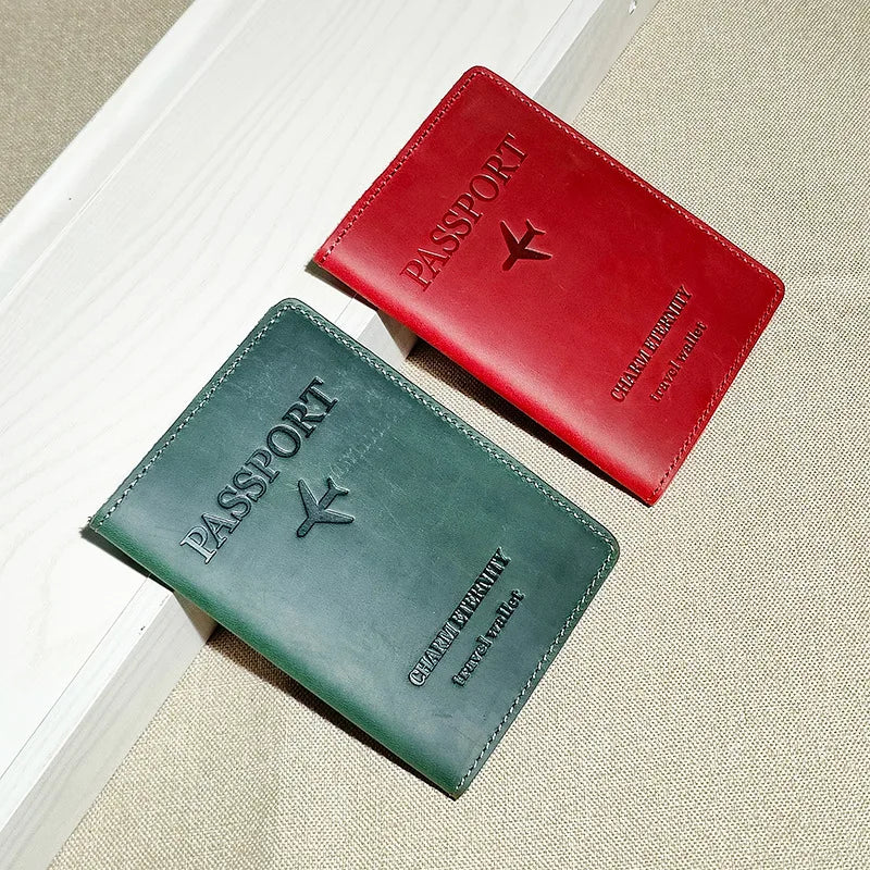 A red leather passport holder and a dark green leather passport wallet are displayed on a light background.