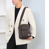 Un mannequin porte un blazer beige sur une chemise noire, tenant un sac à main en cuir marron.