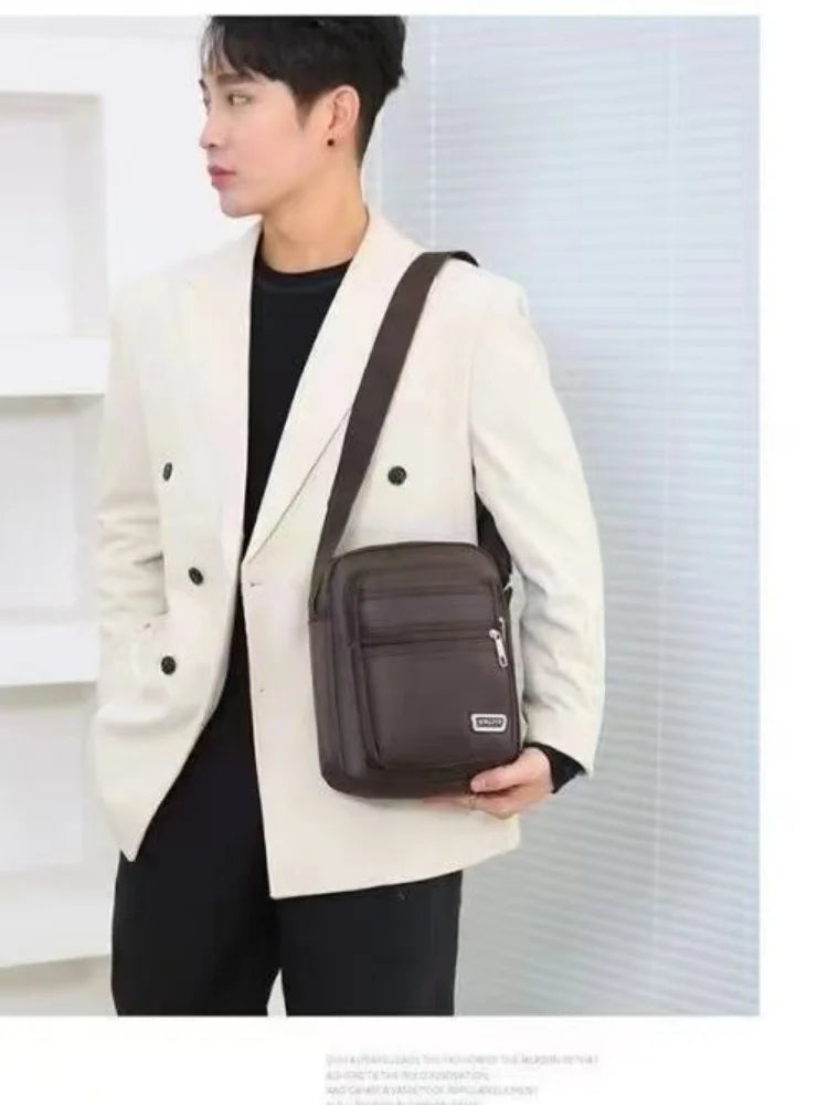 Un mannequin porte un blazer beige sur une chemise noire, tenant un sac à main en cuir marron.