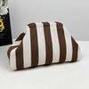 A beige and brown striped knit cloud makeup bag lying on a white surface.