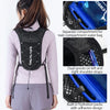 Black hydration running vest with separate compartments and dual shoulder straps worn by a woman.