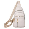 A light beige women's PU leather crossbody chest bag with a matching strap and gold hardware.