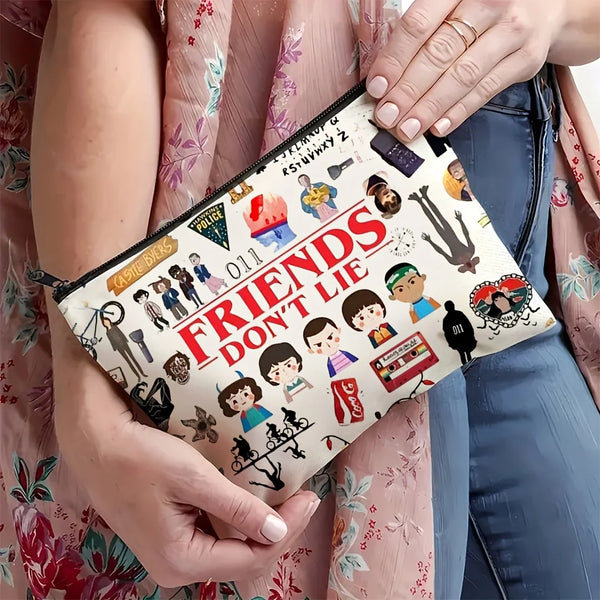 A pink and white zippered makeup bag is held by a woman, featuring the Friends TV show logo.