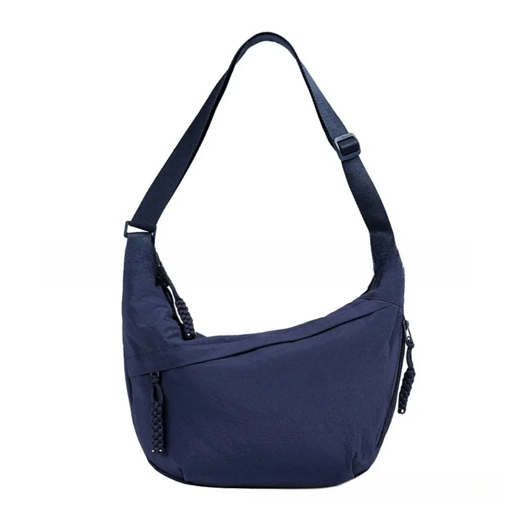 Navy canvas crossbody bag with adjustable strap and zipper detail