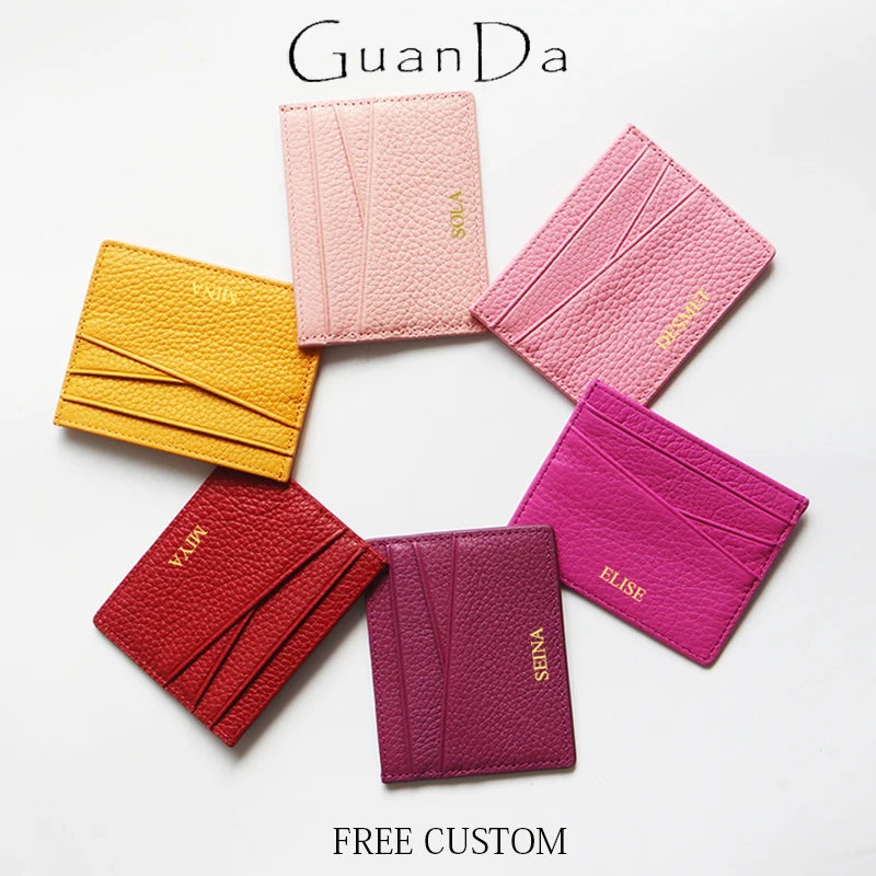 Collection de cinq porte-cartes en cuir véritable rose et magenta disposés en cercle.