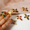 A hand holds several gold-plated cross and Virgin Mary charm pendants adorned with cubic zirconia stones.