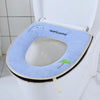 A blue plush waterproof toilet seat cover with a welcome message and a small palm tree design is shown on a white toilet.