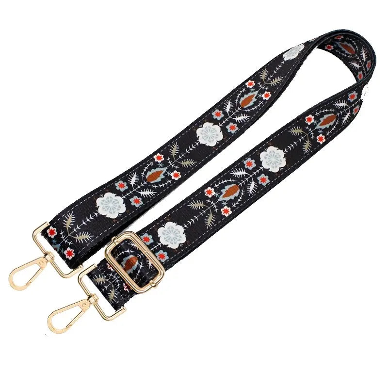 Black nylon crossbody bag strap with floral and geometric patterns and gold hardware