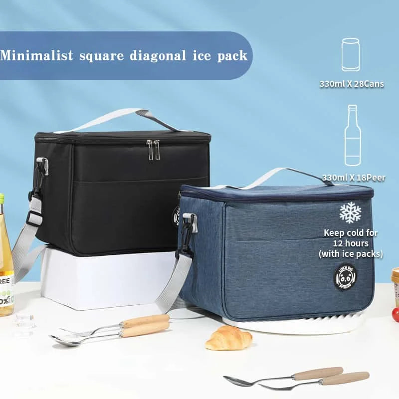 Schwarze und blaue isolierte Thermotasche mit Kühlpacks, Besteck und Brot auf weißem Untergrund.
