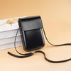 A black vintage PU leather crossbody bag with an adjustable strap resting on a light beige surface.