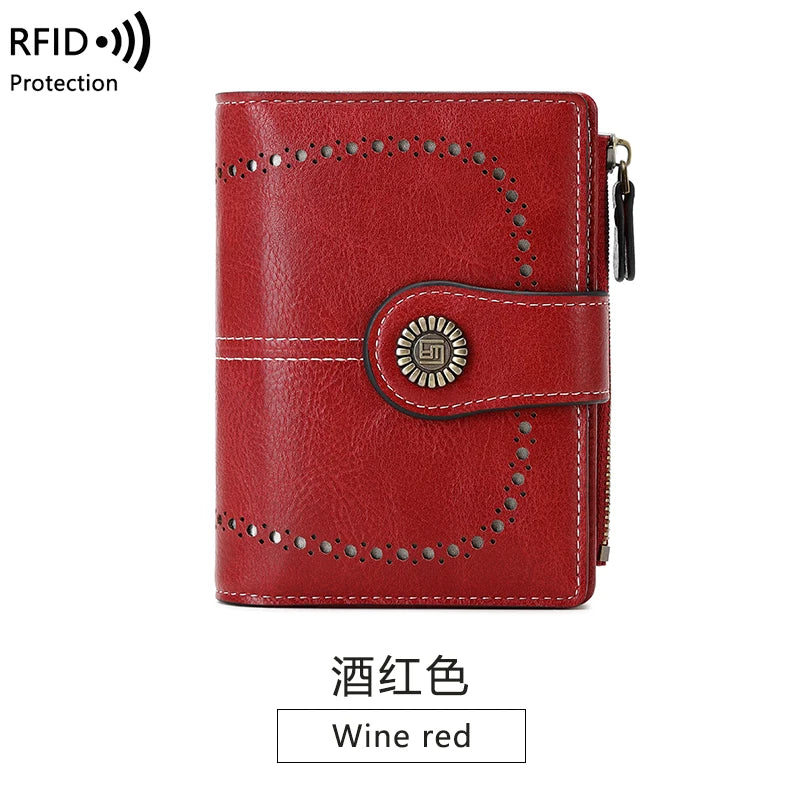 A red leather multi-fold wallet with stitching and a decorative metal emblem.
