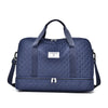 A navy blue quilted nylon travel duffle bag with two handles and a zippered compartment.