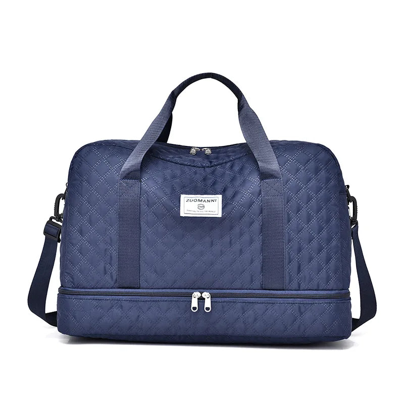 A navy blue quilted nylon travel duffle bag with two handles and a zippered compartment.