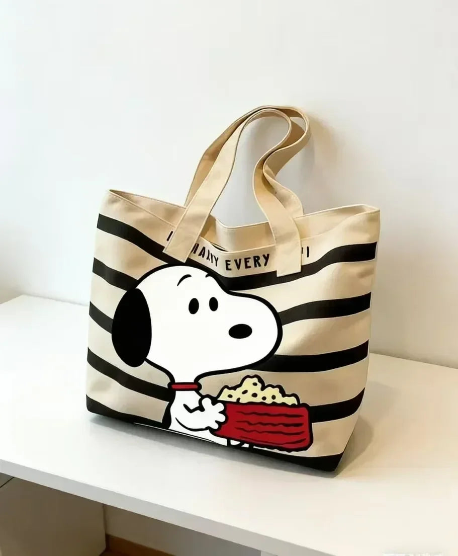 A beige canvas shoulder bag featuring a Snoopy cartoon design with food inside.