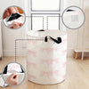 A white fabric storage basket with pink bows is shown, demonstrating its foldable design and mesh lining.