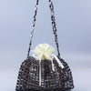 A handmade dumpling bag made of silver and gold beads with a white ribbon drawstring.
