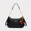 Black leather crescent crossbody bag with gold chain strap and red cherries embellishments