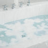 A disposable bathtub liner set with chrome fixtures and white plastic covering filled with soapy water.