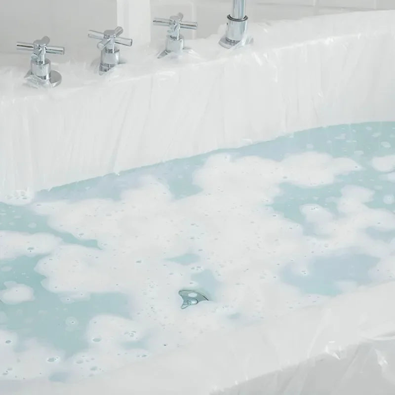 A disposable bathtub liner set with chrome fixtures and white plastic covering filled with soapy water.