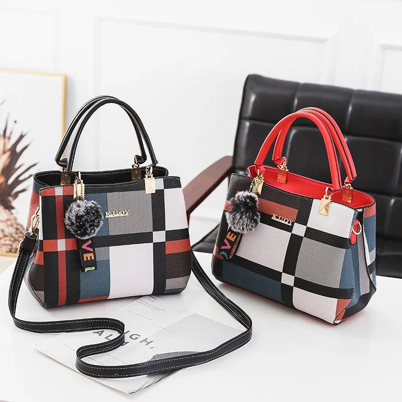Sac bandoulière en cuir PU à carreaux noir et blanc avec accents rouges, posé sur une surface blanche.