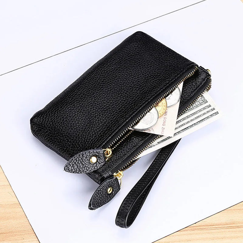 Black genuine leather wristlet clutch wallet with gold zipper closure and cash inside